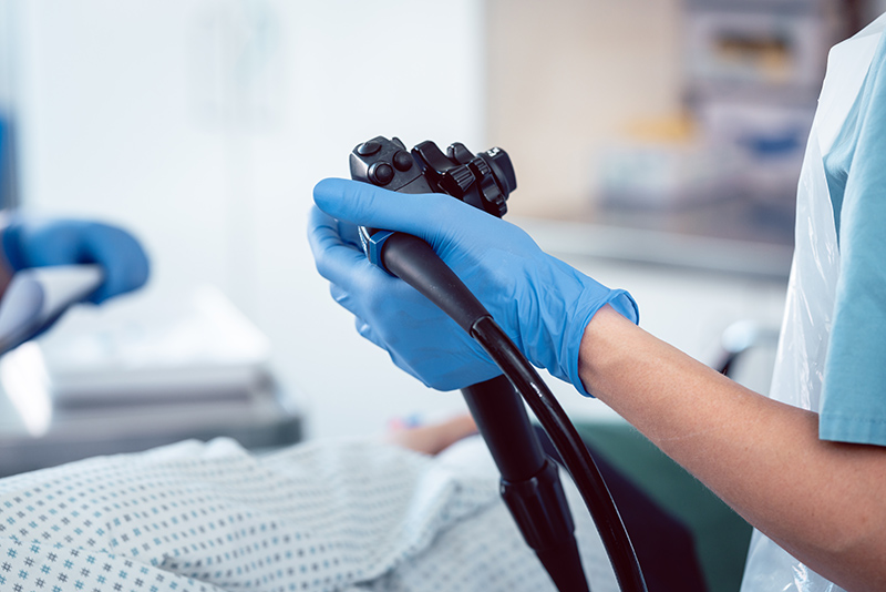 Colorectal specialist holding endoscope during colonoscopy